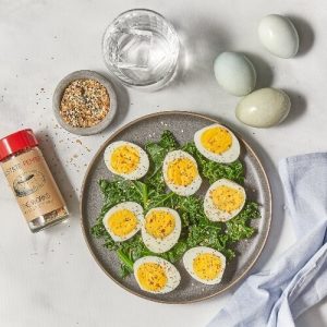 Azuluna Foods Hard Boiled Eggs with a Seasoning Shaker in a staged photo on marble counter